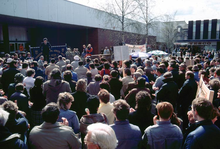 The crowd gather and listen attentively.